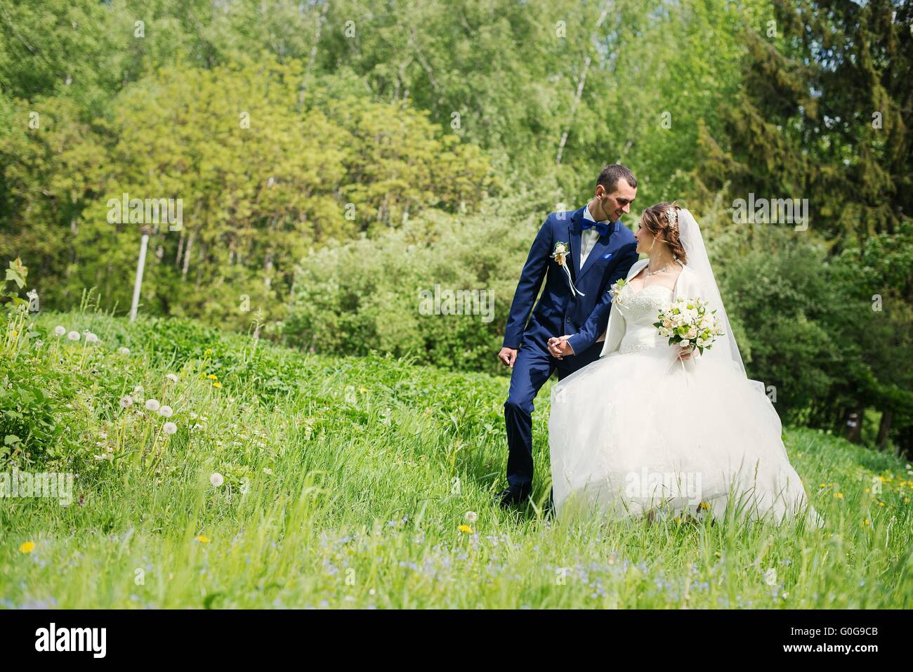 Giovane e bella carino sposi passeggiate al parco Foto Stock