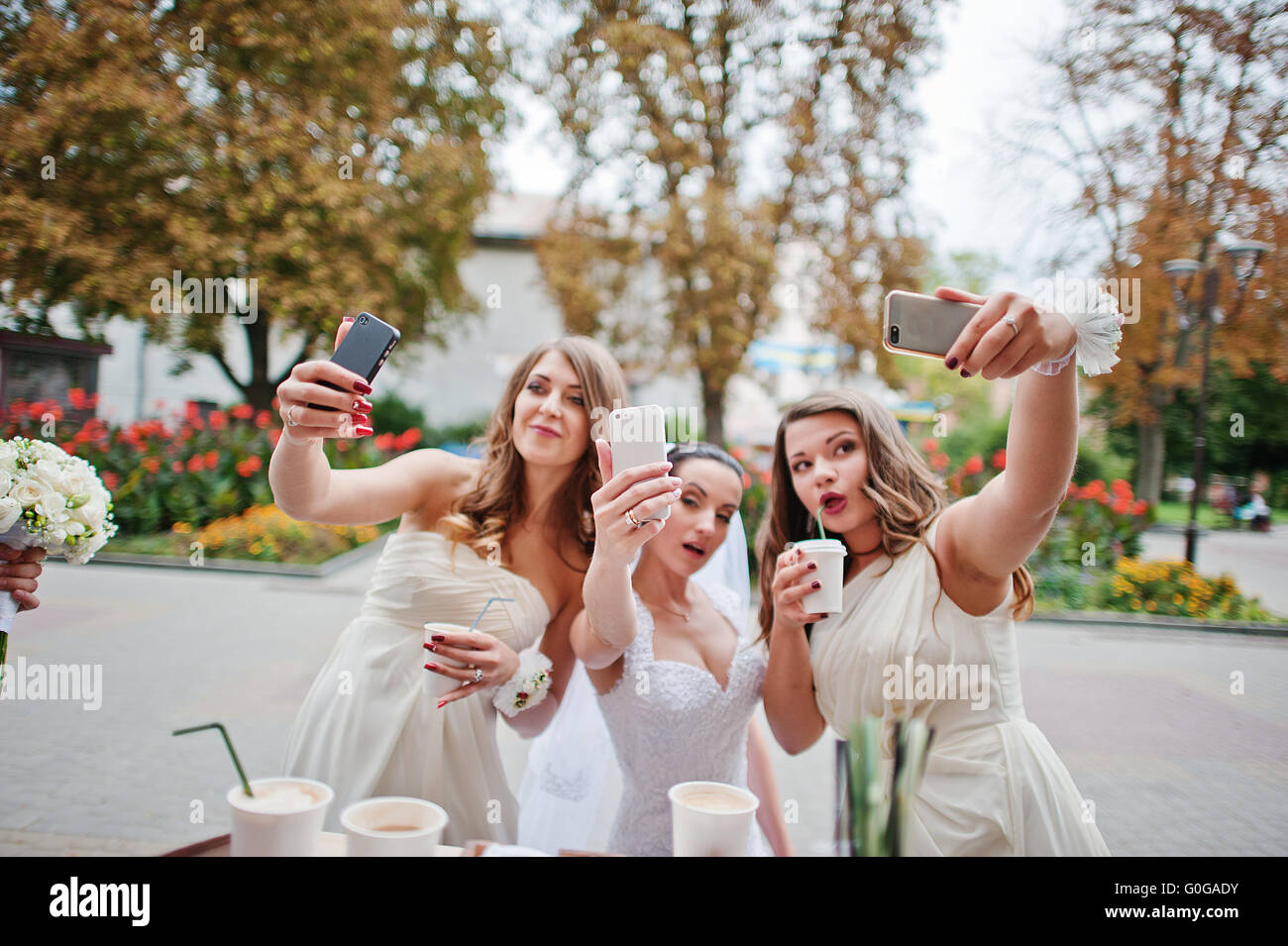 Giovani damigella con sposa facendo selfie Foto Stock