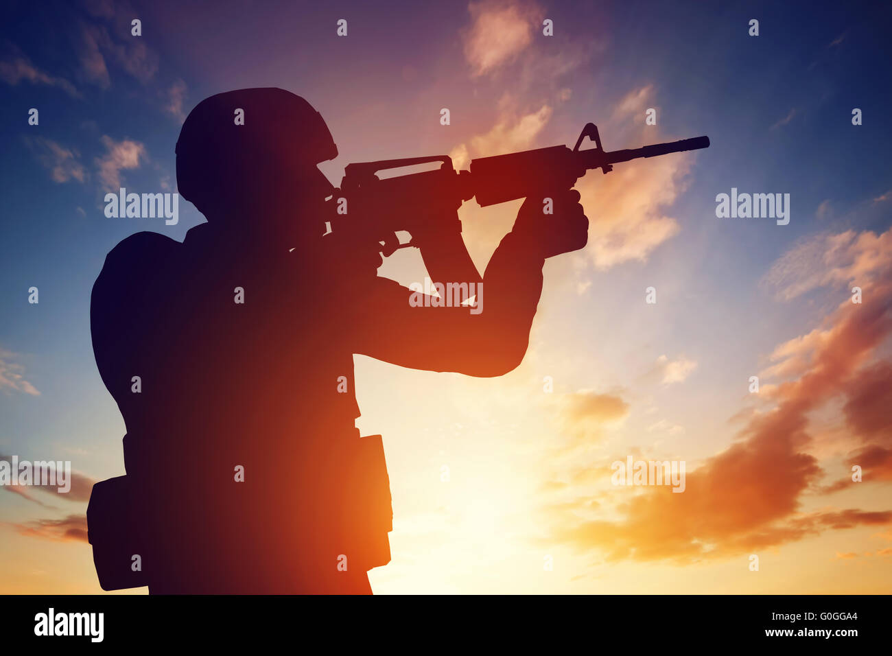 Soldato sparare con il suo fucile al tramonto. La guerra, esercito, militare. Foto Stock