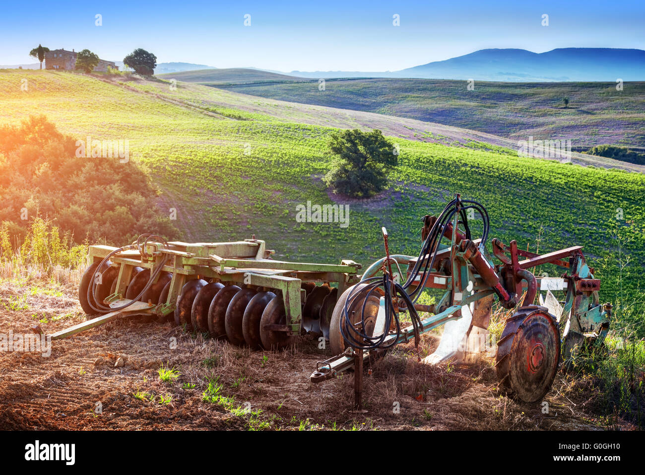 Paesaggio toscano a sunrise. Retrò macchine per l'agricoltura. Italia Foto Stock