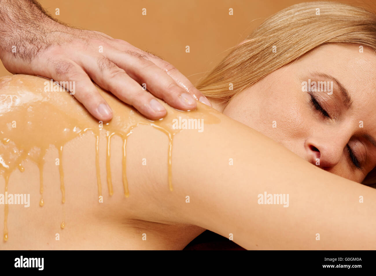 Giovane donna che riceve un miele-sale-massaggi Foto Stock