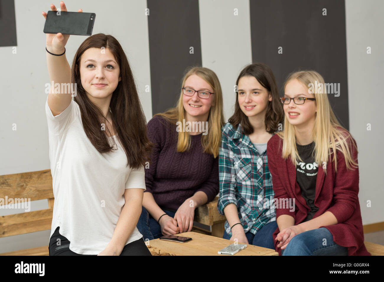 Gruppo adolescente con quattro ragazze rendendo con uno smartphone Selfie Foto Stock