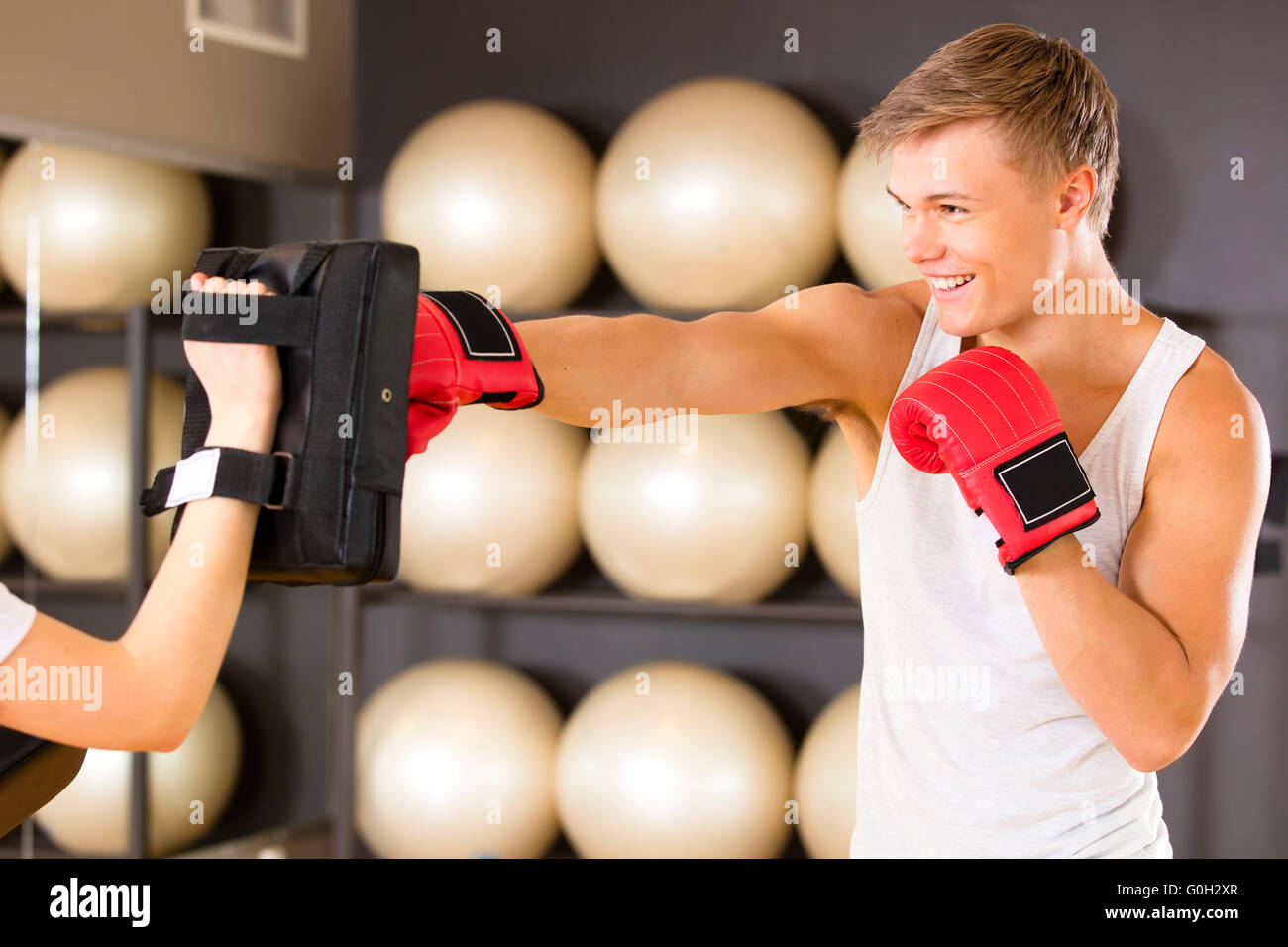 Uomo sorridente boxing training presso la palestra fitness Foto Stock