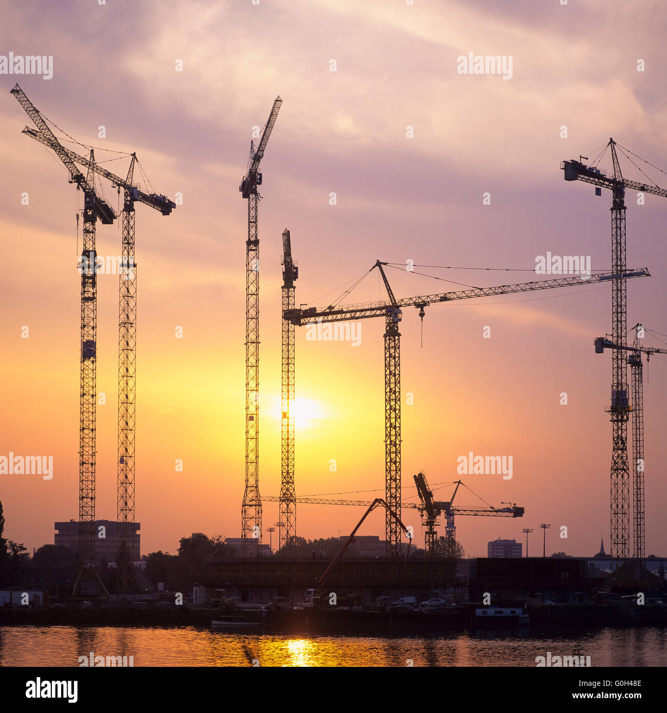 Sagome di gru edili sul sito di costruzione al tramonto, Francia, Europa Foto Stock