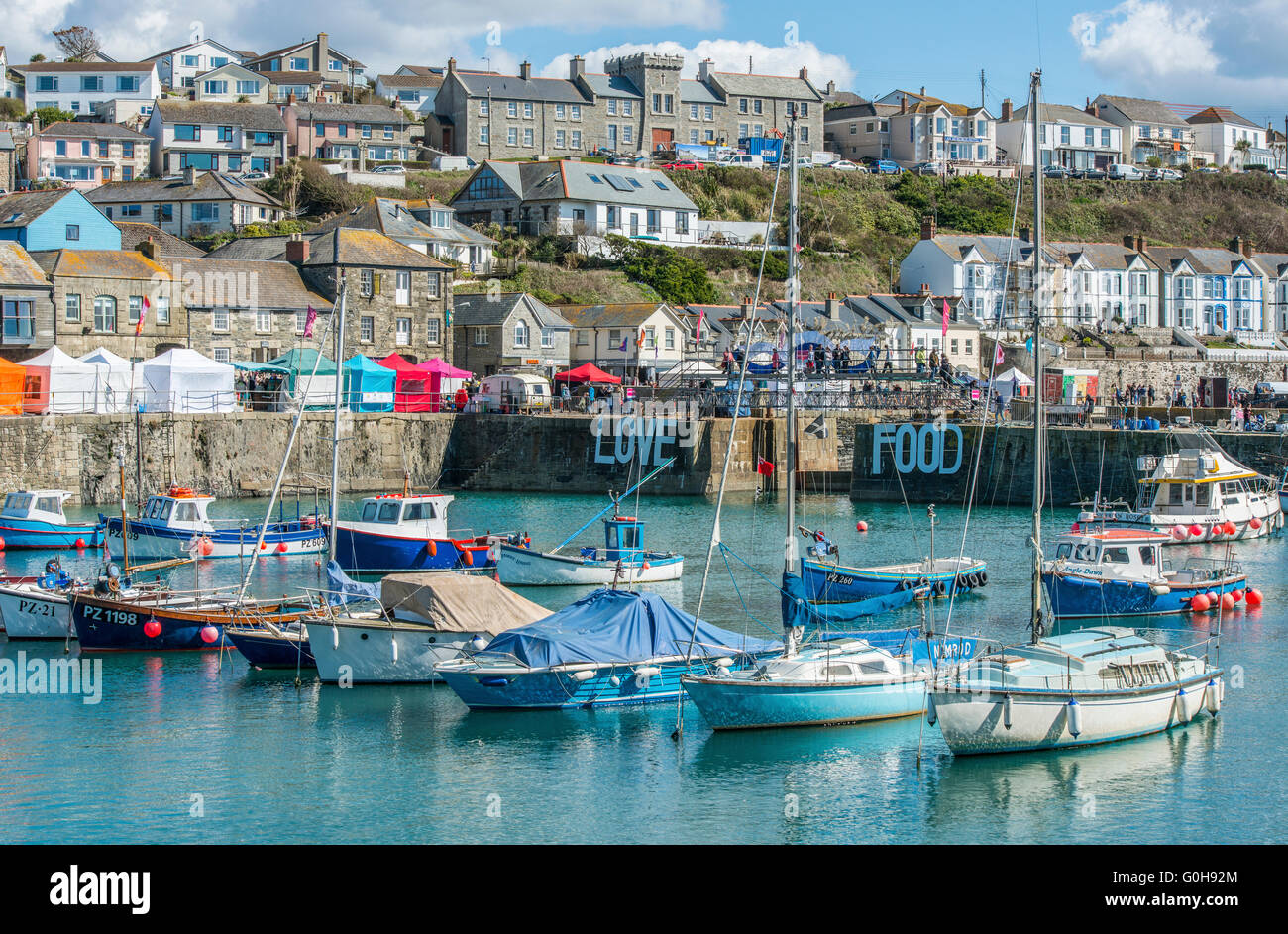Porthleven Porto Interno con barche ormeggiate durante il mese di aprile 2016 Food Festival, in Cornovaglia in una giornata di sole Foto Stock