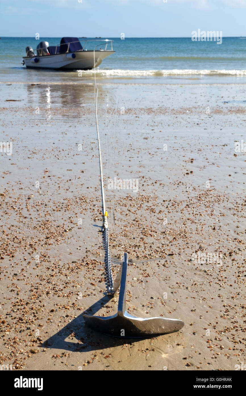 Il motoscafo sul dispositivo di ancoraggio in corrispondenza di una spiaggia sabbiosa Foto Stock