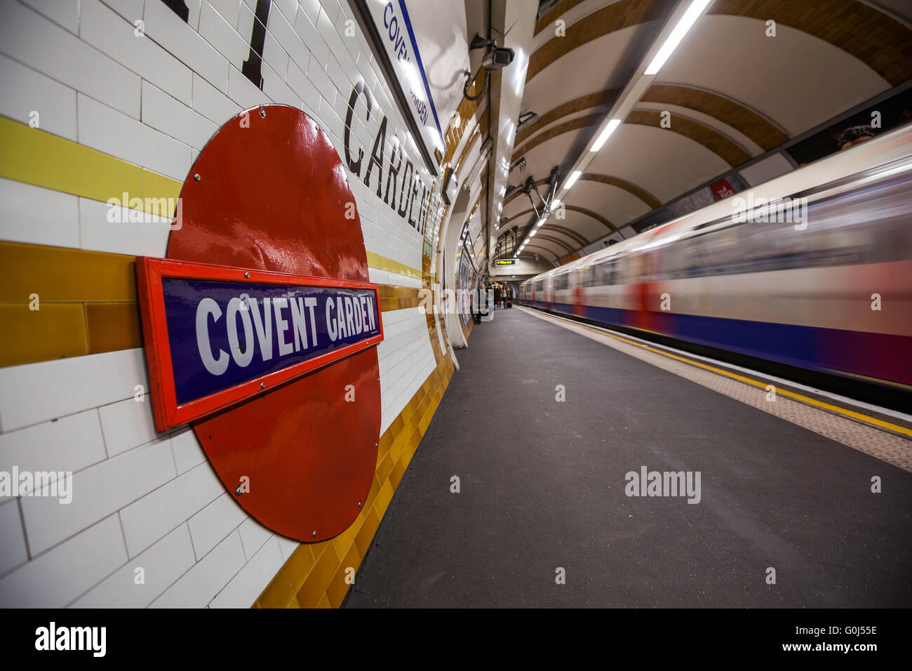Il Covent Garden la stazione della metropolitana di Londra, Regno Unito, shot mentre un treno sta lasciando la stazione Foto Stock