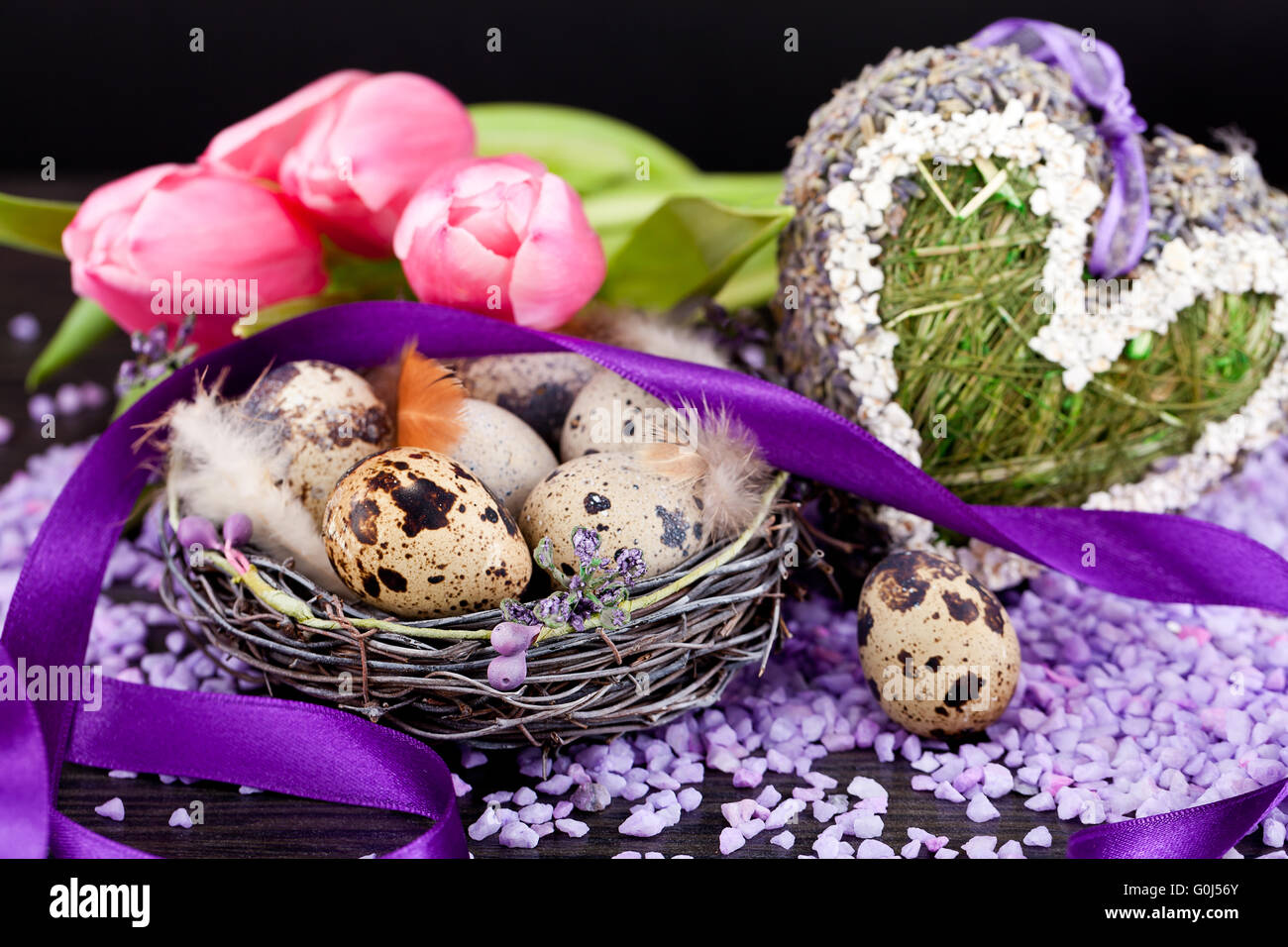 Tulipani rosa e uova di colore marrone con nastro viola decorazione di pasqua Foto Stock