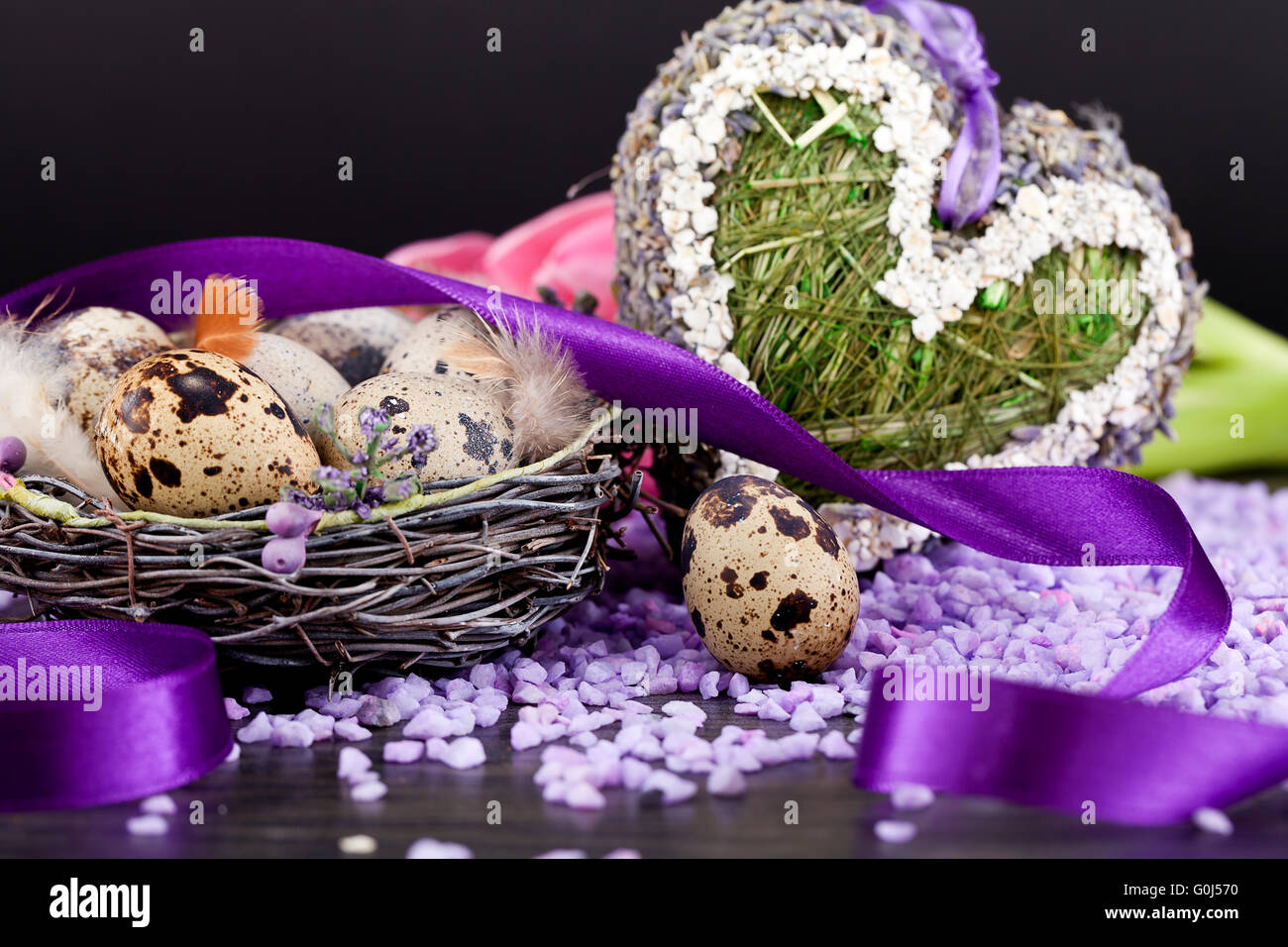 Tulipani rosa e uova di colore marrone con nastro viola decorazione di pasqua Foto Stock