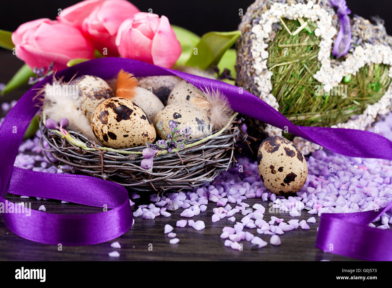 Tulipani rosa e uova di colore marrone con nastro viola decorazione di pasqua Foto Stock