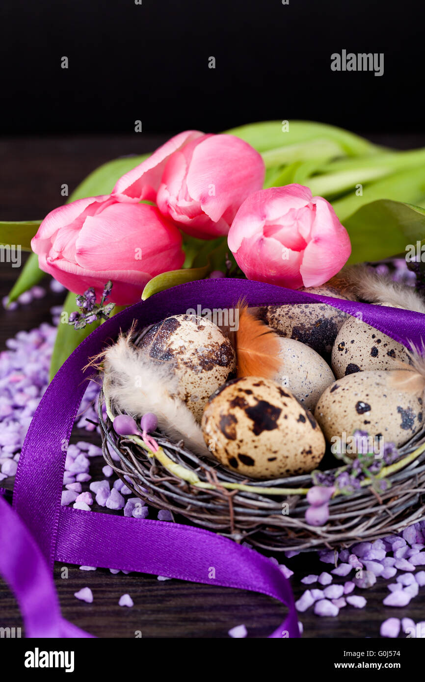 Tulipani rosa e uova di colore marrone con nastro viola decorazione di pasqua Foto Stock