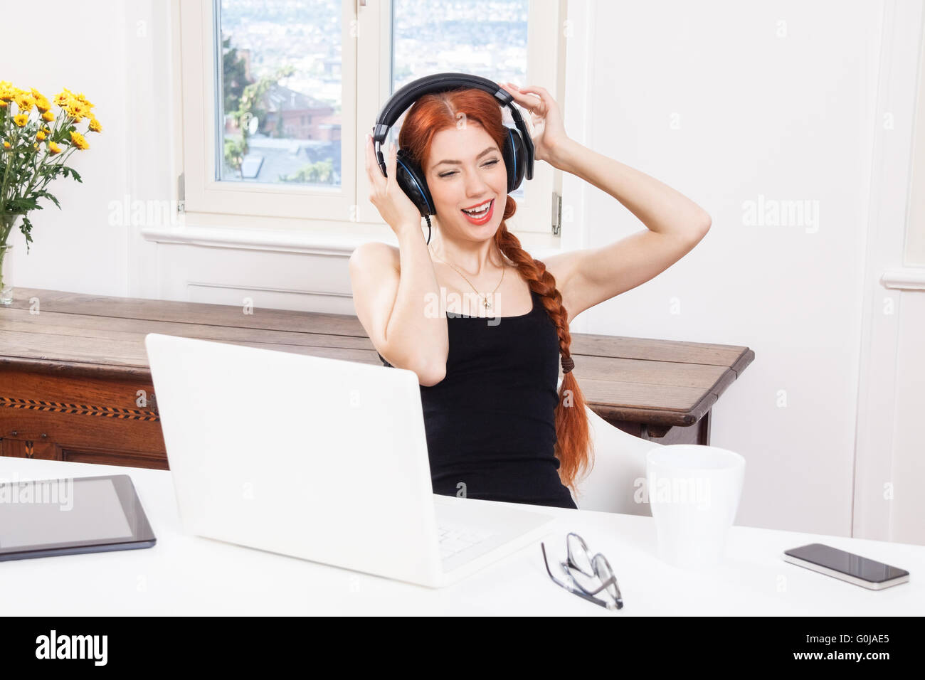 Felice giovane donna ascoltando musica in camera sua Foto Stock