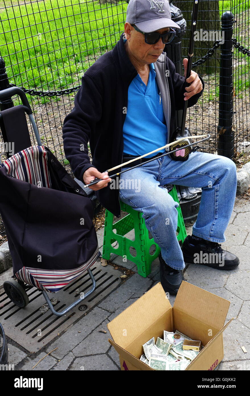 Uomo cinese la riproduzione del Erhu Cinese (violino) a Battery Park, New York City, NY, STATI UNITI D'AMERICA Foto Stock