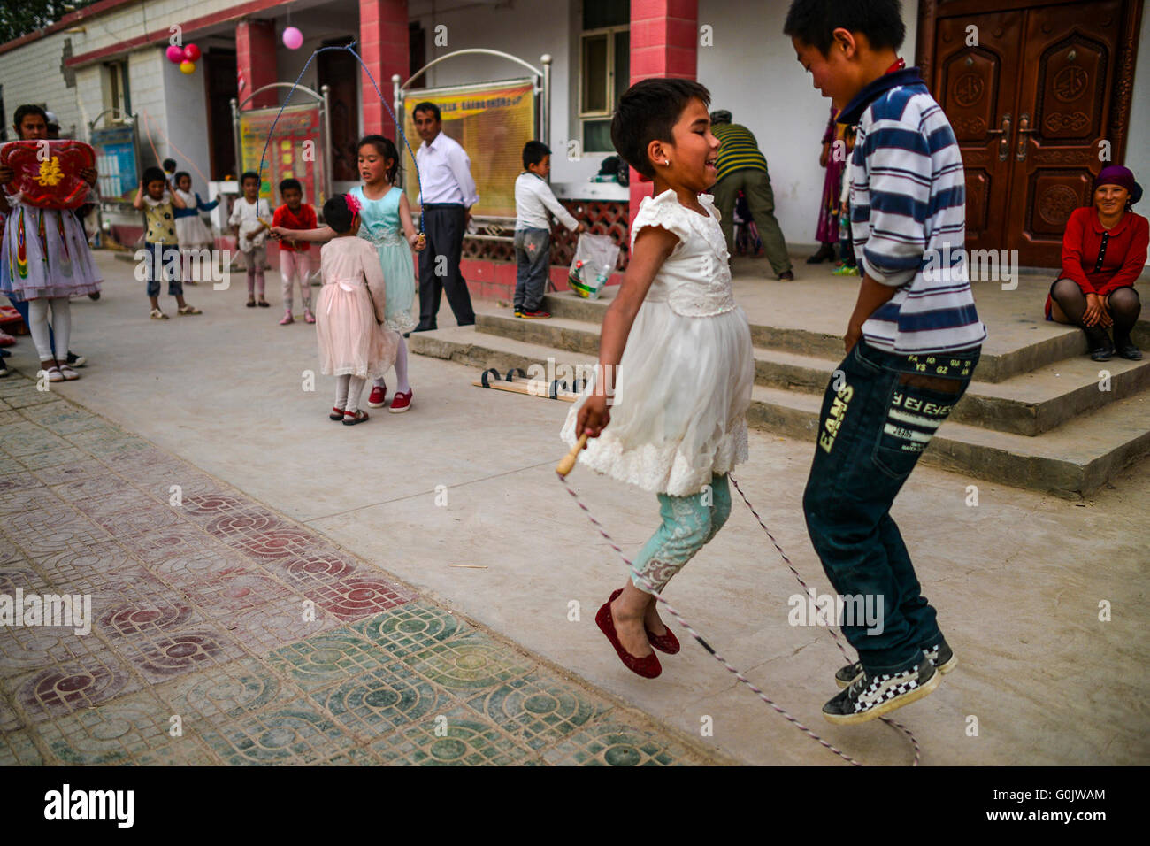 Yopurga cinese Xinjiang Uygur Regione autonoma. Il 1 maggio, 2016. I bambini saltare corde in Kure villaggio di Yopurga County, a nord-ovest della Cina di Xinjiang Uygur Regione autonoma, 1 maggio 2016. Gli abitanti di un villaggio di Uygur Han e gruppi etnici in Kure Village detenute attività ricreative per festeggiare il giorno di maggio vacanze. © Shen Qiao/Xinhua/Alamy Live News Foto Stock