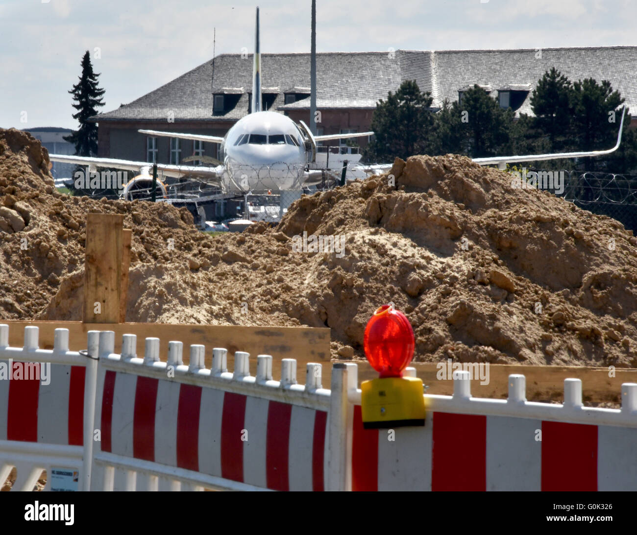 Un airplan parcheggio dietro un sito in costruzione presso il Terminal D all'aeroporto di Schoenefeld, Germania, 2 maggio 2016. Direttamente accanto al terminale del vecchio campo d'aviazione, le posizioni di parcheggio per le macchine di compagnie aeree a basso costo sono costruiti, che dopo l'apertura di Willy Brandt Aeroporto BER non avrà abbastanza spazio più. Foto: BERND SETTNIK/dpa Foto Stock