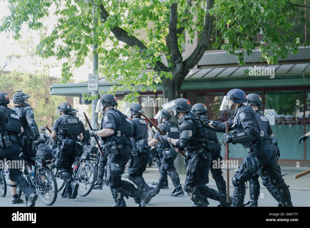 Seattle, WA, Stati Uniti d'America. Il 1 maggio, 2016. Gli ufficiali di polizia carica improvvisamente aggressivo verso un gruppo di manifestanti e reindirizzare un percorso marching. Foto Stock