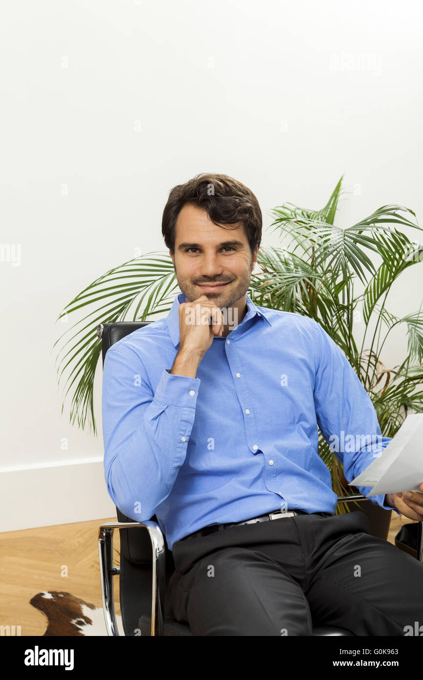 Giovane uomo leggendo gli accordi scritti per il lavoro Foto Stock