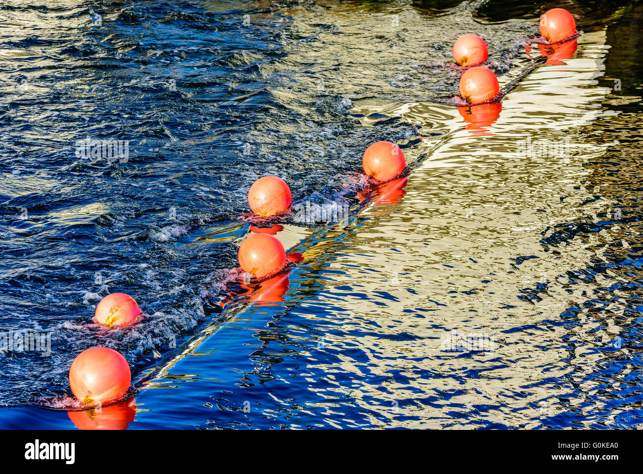 Arancio brillante boe contrassegnare un sommerso saracinesca controllando la leva di acqua in corrispondenza di un canale Foto Stock