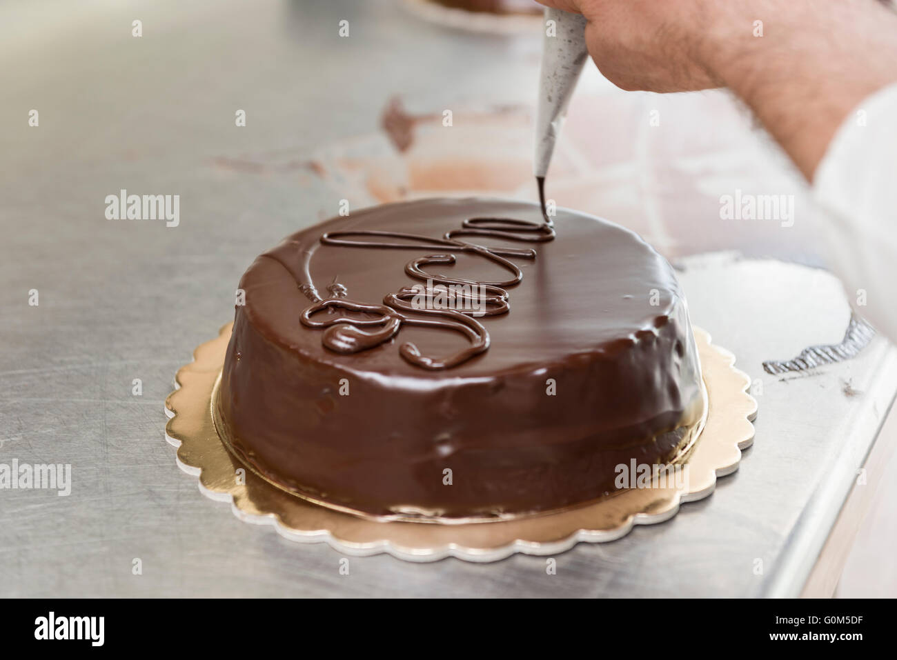 Pastry chef guarnire una torta al cioccolato fuso Foto stock - Alamy