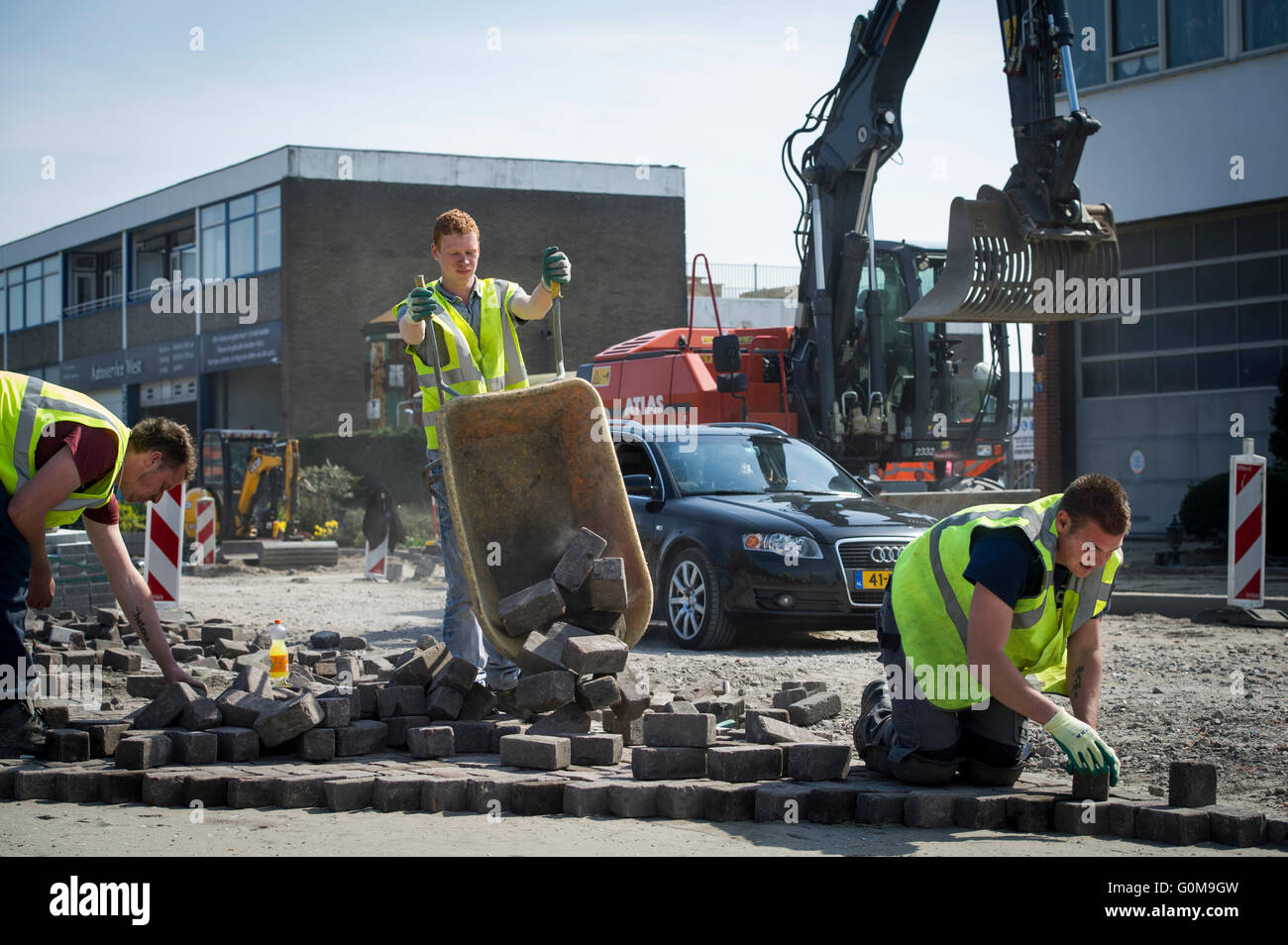 Gli uomini di lavoro pavimentazione di una strada. Foto Stock