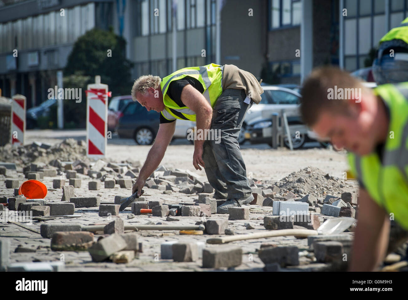 Gli uomini di lavoro pavimentazione di una strada. Foto Stock