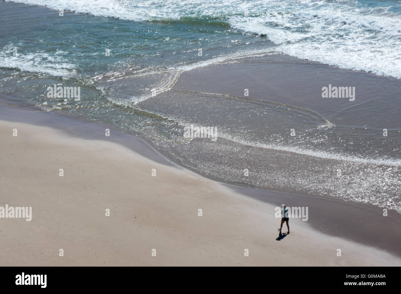 Una persona a piedi lungo la spiaggia sulla Gold Coast di Queensland in Australia Foto Stock