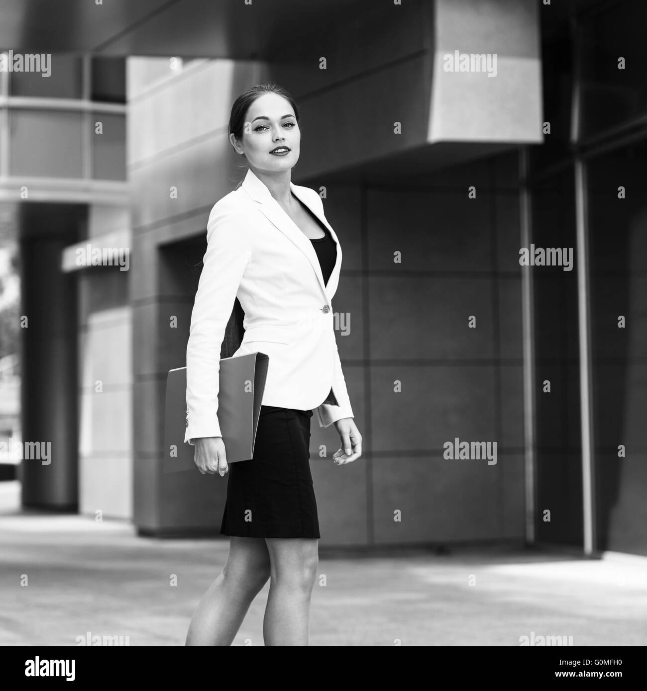 Felice giovane donna di affari con una cartella Foto Stock