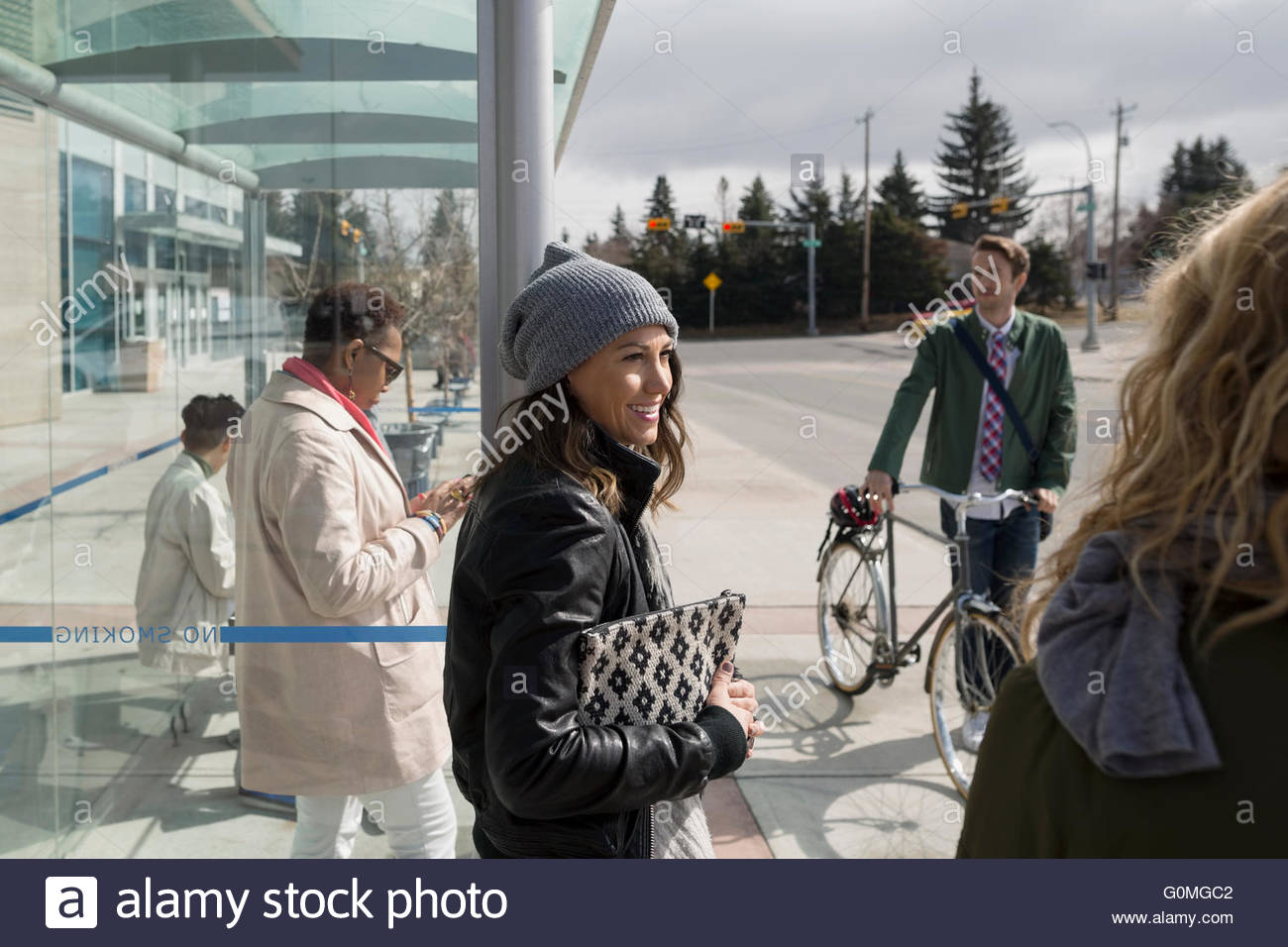 Persone in attesa al sunny fermata bus Foto Stock
