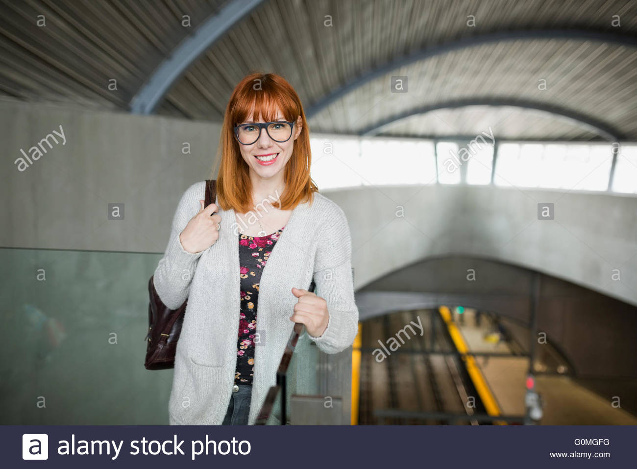 Ritratto di donna sorridente alla stazione ferroviaria Foto Stock