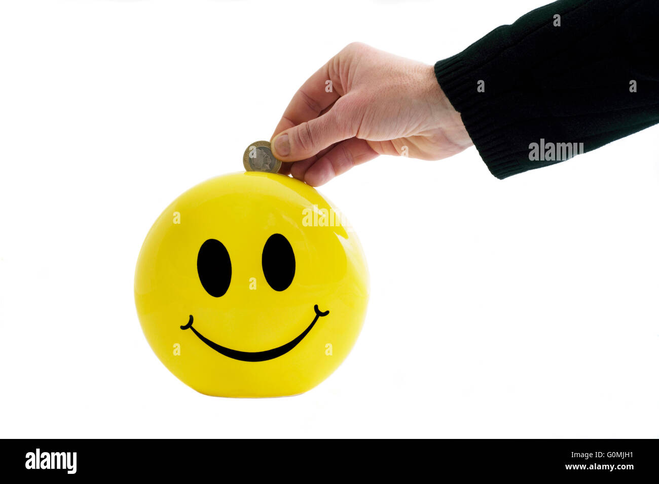 Uomo di mettere il denaro in un risparmio smiley box Foto Stock
