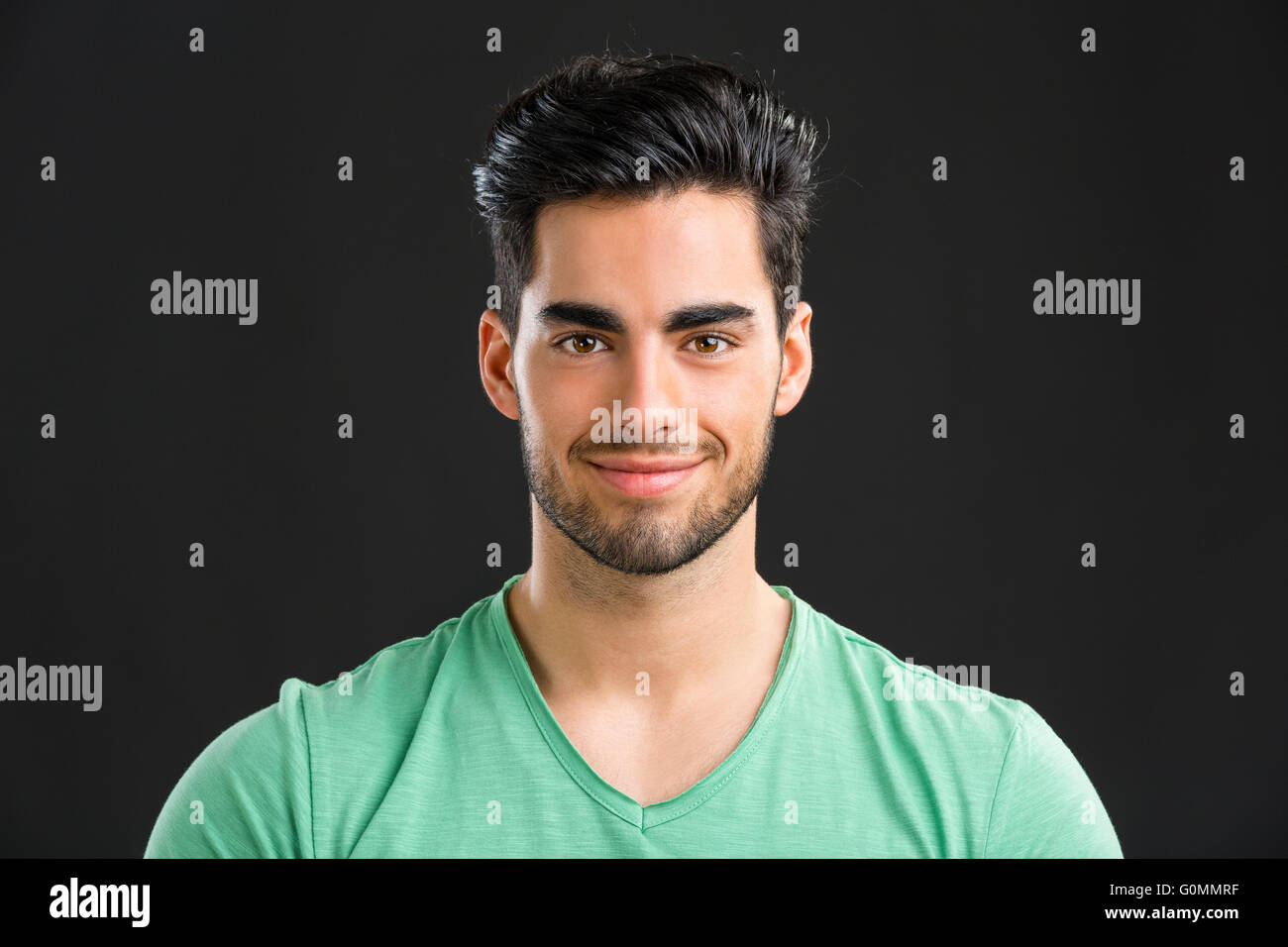 Ritratto di bel giovane uomo sorridente, isolata su uno sfondo grigio Foto Stock