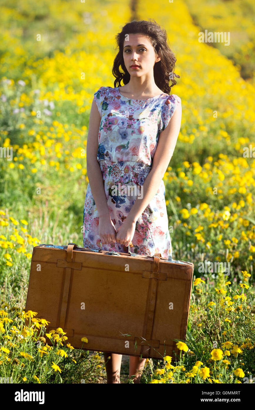 Immagine della giovane donna in daisy archiviato orecon retrò valigia in mano Foto Stock