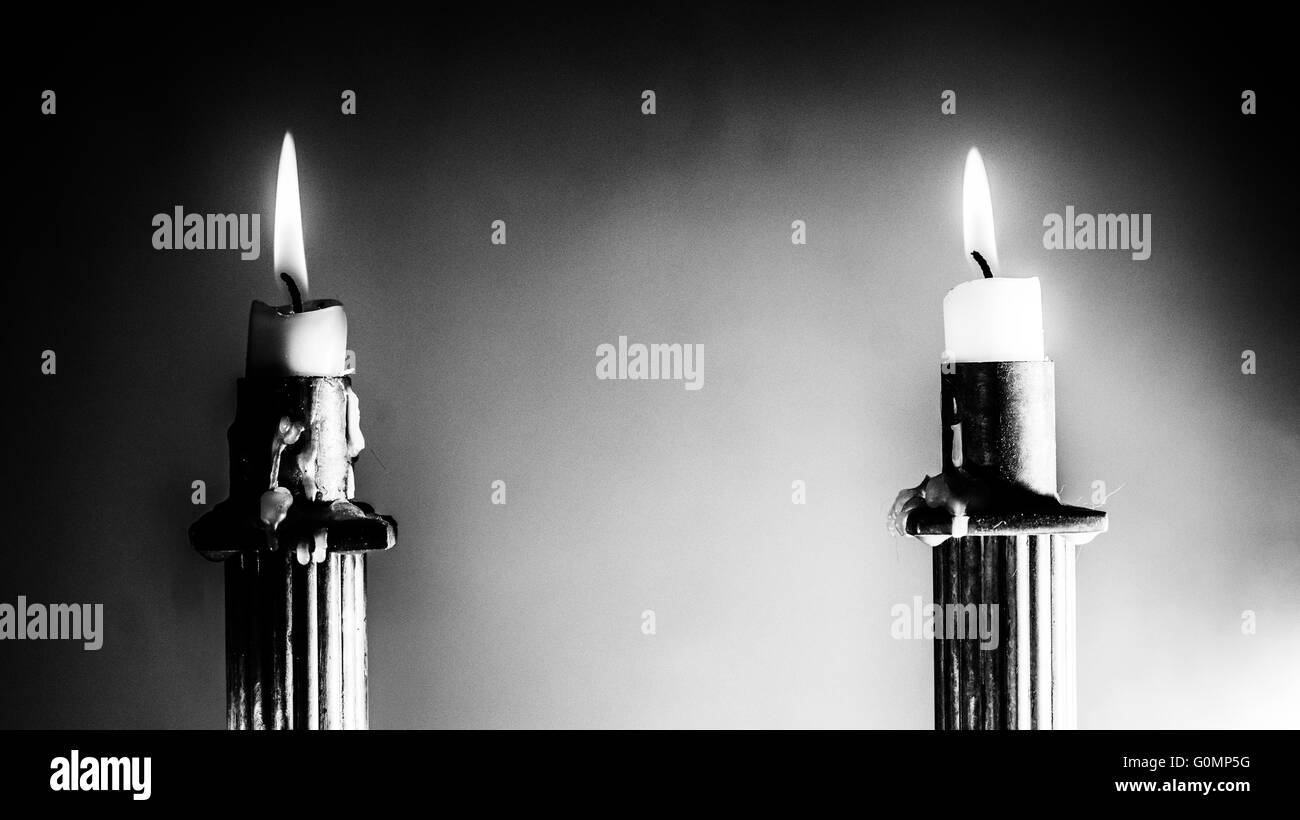 2 candele accese in Stile Impero portacandele in bianco e nero a contrasto duro Foto Stock
