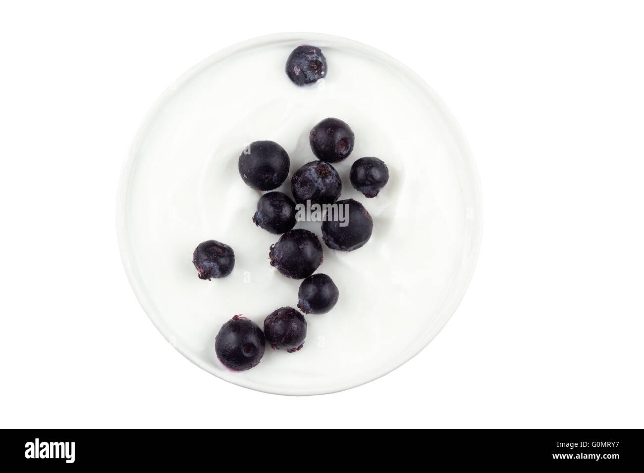 Bacche di Saskatoon cosparse in una ciotola di yogurt greco su fondo bianco. Conosciuto anche come Junebries. Foto Stock
