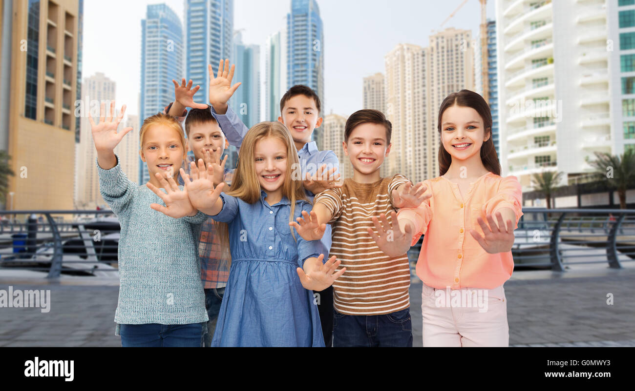 Gruppo di bambini felici sventolare le mani Foto Stock