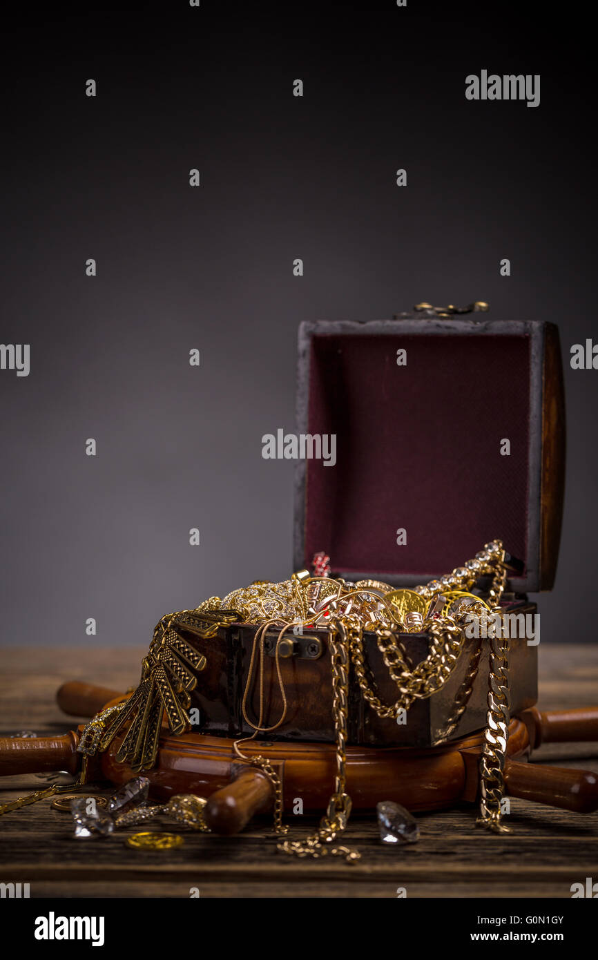 Torace dei pirati con gioielli in oro su sfondo di legno Foto Stock
