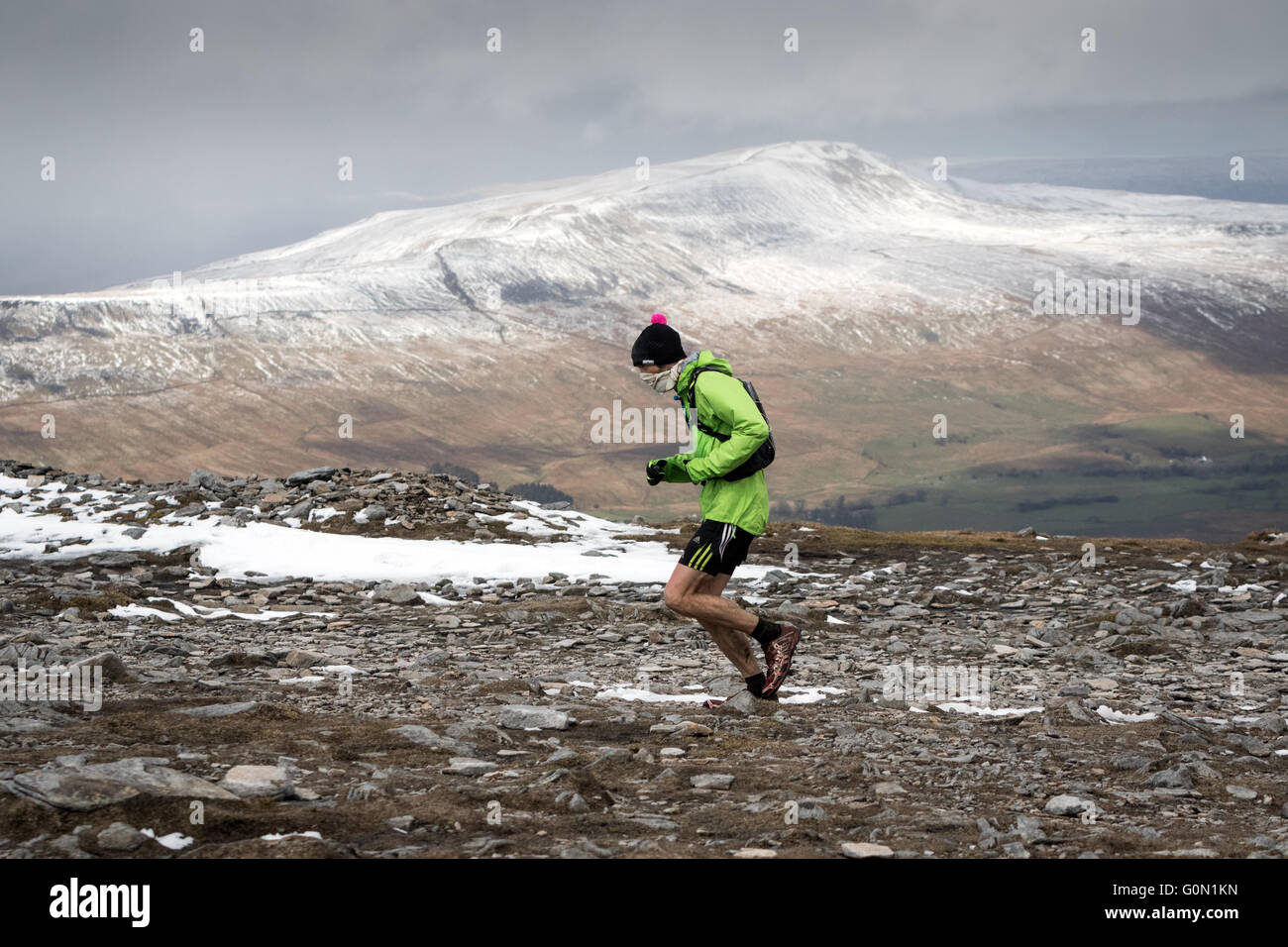 Una guida sul vertice di Ingleborough durante l annuale tre picchi di gara. La distanza è una coperta di neve Whernside Foto Stock