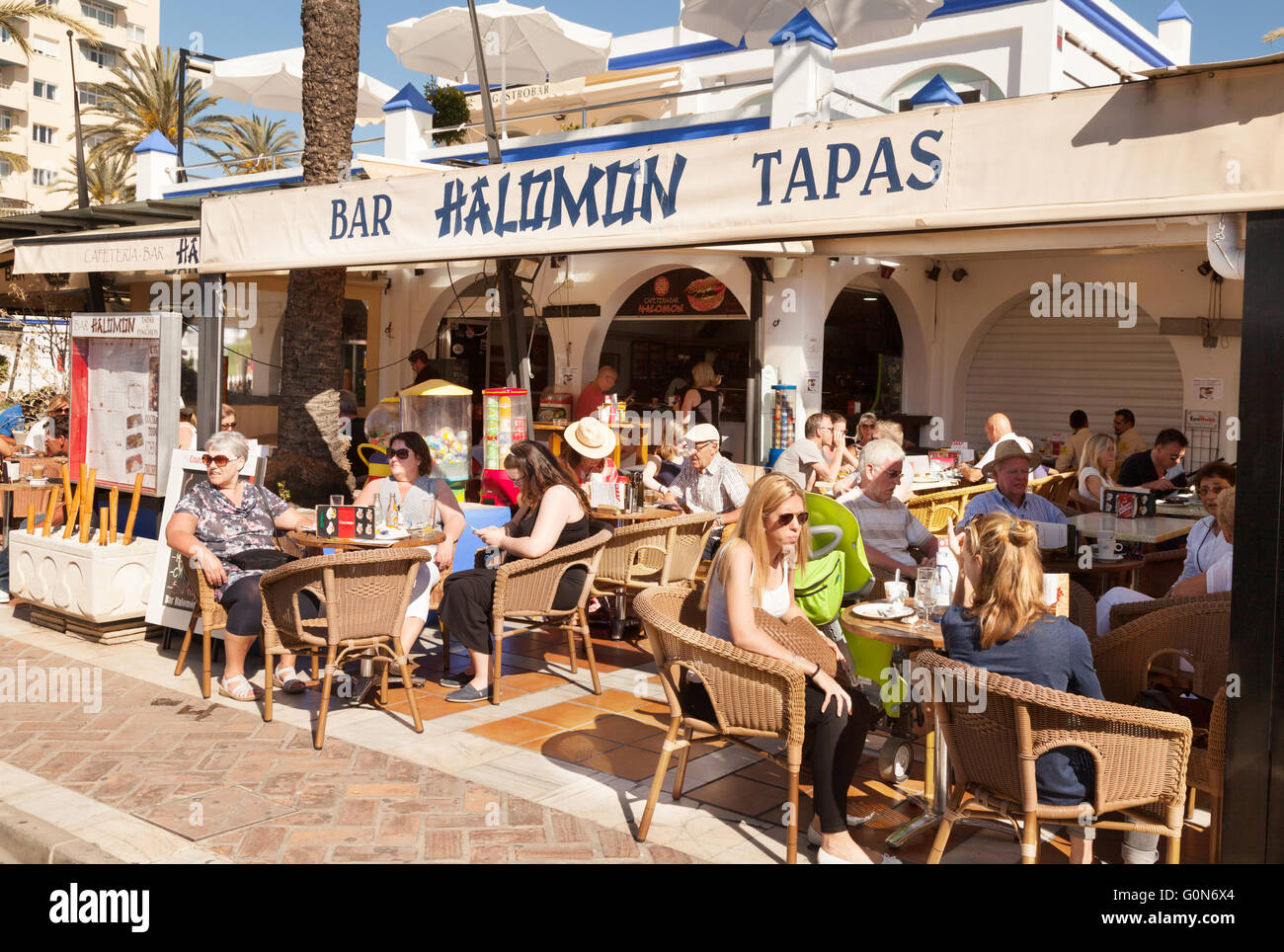 La gente seduta a un tapas bar nel sole di primavera, Estepona marina, Costa del Sol, Andalusia, Spagna Europa Foto Stock