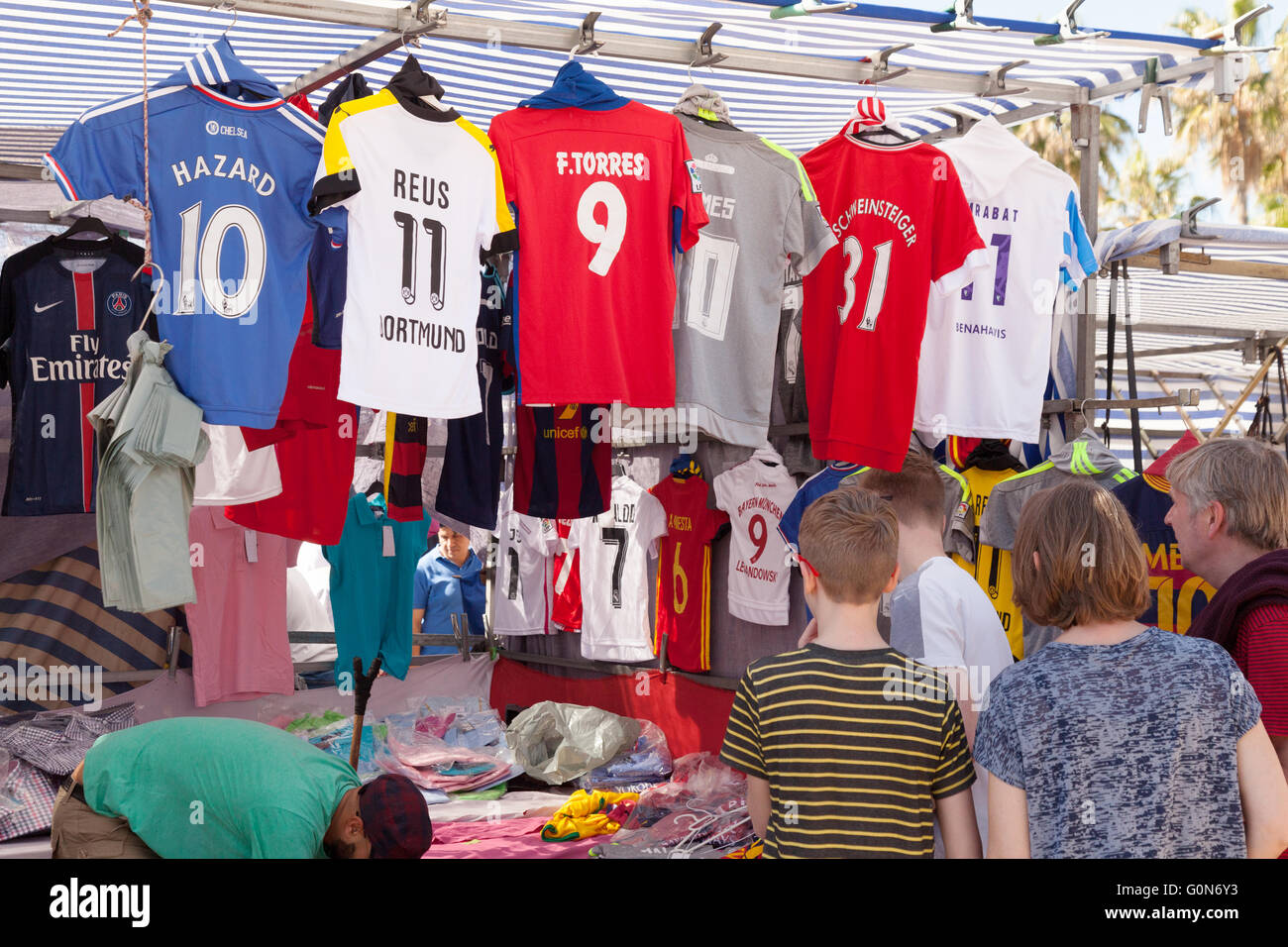 Un bambino guardando magliette da calcio a un mercato in stallo, Estepona mercato, Andalusia, Spagna, Europa Foto Stock Un bambino guardando magliette da calcio a un mercato in stallo, Estepona mercato, Andalusia, Spagna, Europa Foto Stock