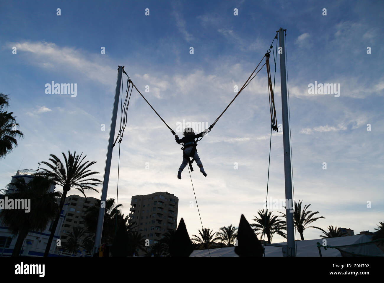 Silhouette di un giovane bambino su un trampolino verso il tramonto, Estepona, Spagna, Europa - Concetto di infanzia, riproduzione Foto Stock