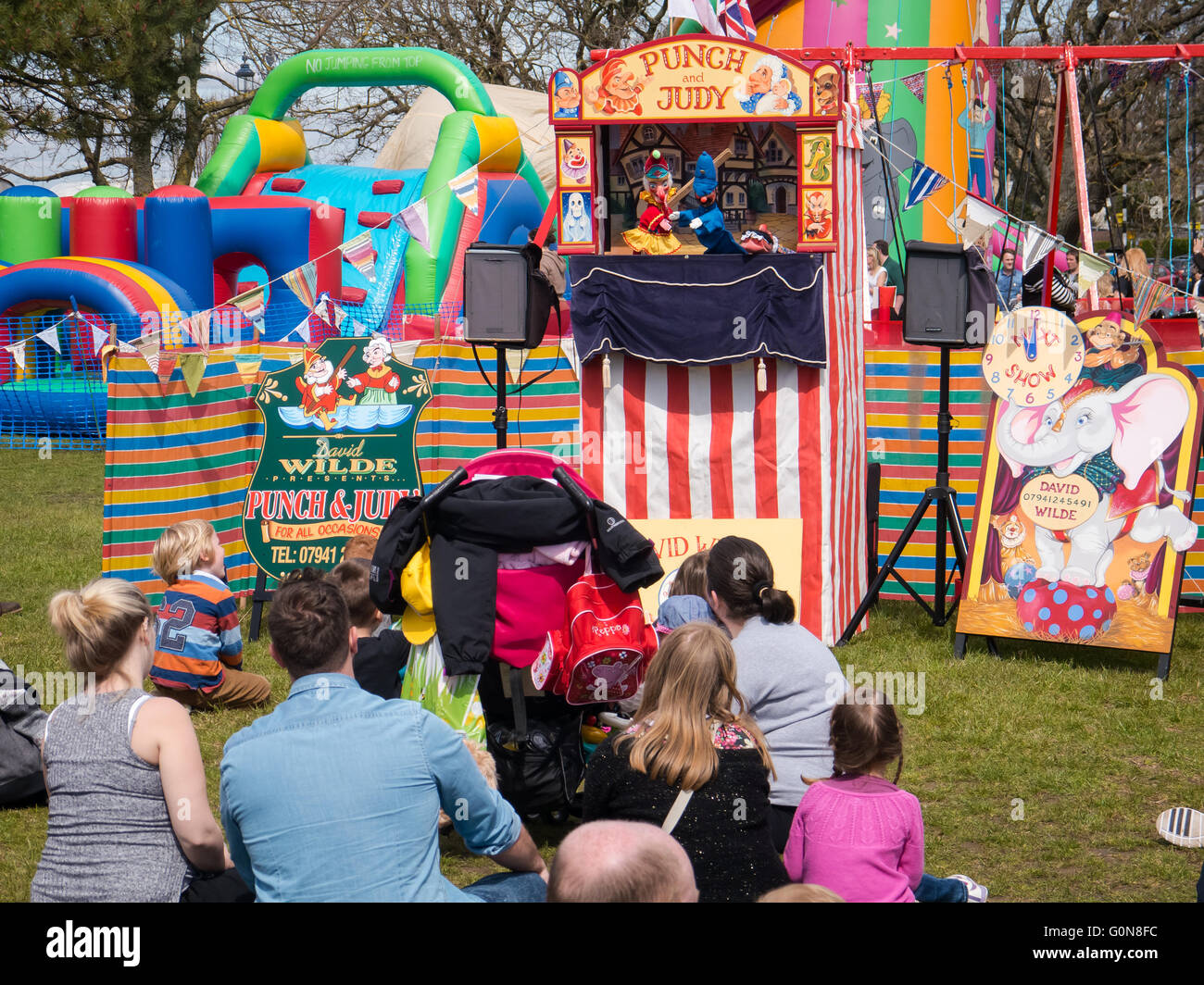 Guardare la gente di un tradizionale Punch e Judy spettacolo di marionette a una fiera estiva Foto Stock