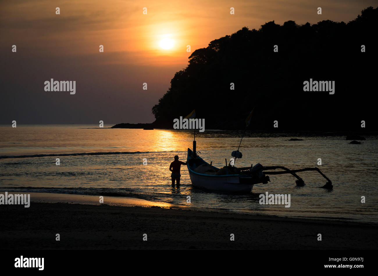 Un pescatore di Agonda, Goa, India è sempre pronto in un tramonto dorato a lasciare per una notte di pesca Foto Stock