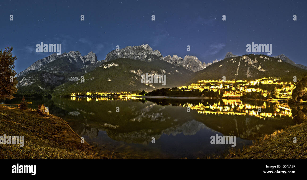 Paesaggio notturno del lago di Molveno e Dolomiti di Brenta gruppo in una tranquilla serata estiva con cielo stellato in background. Foto Stock