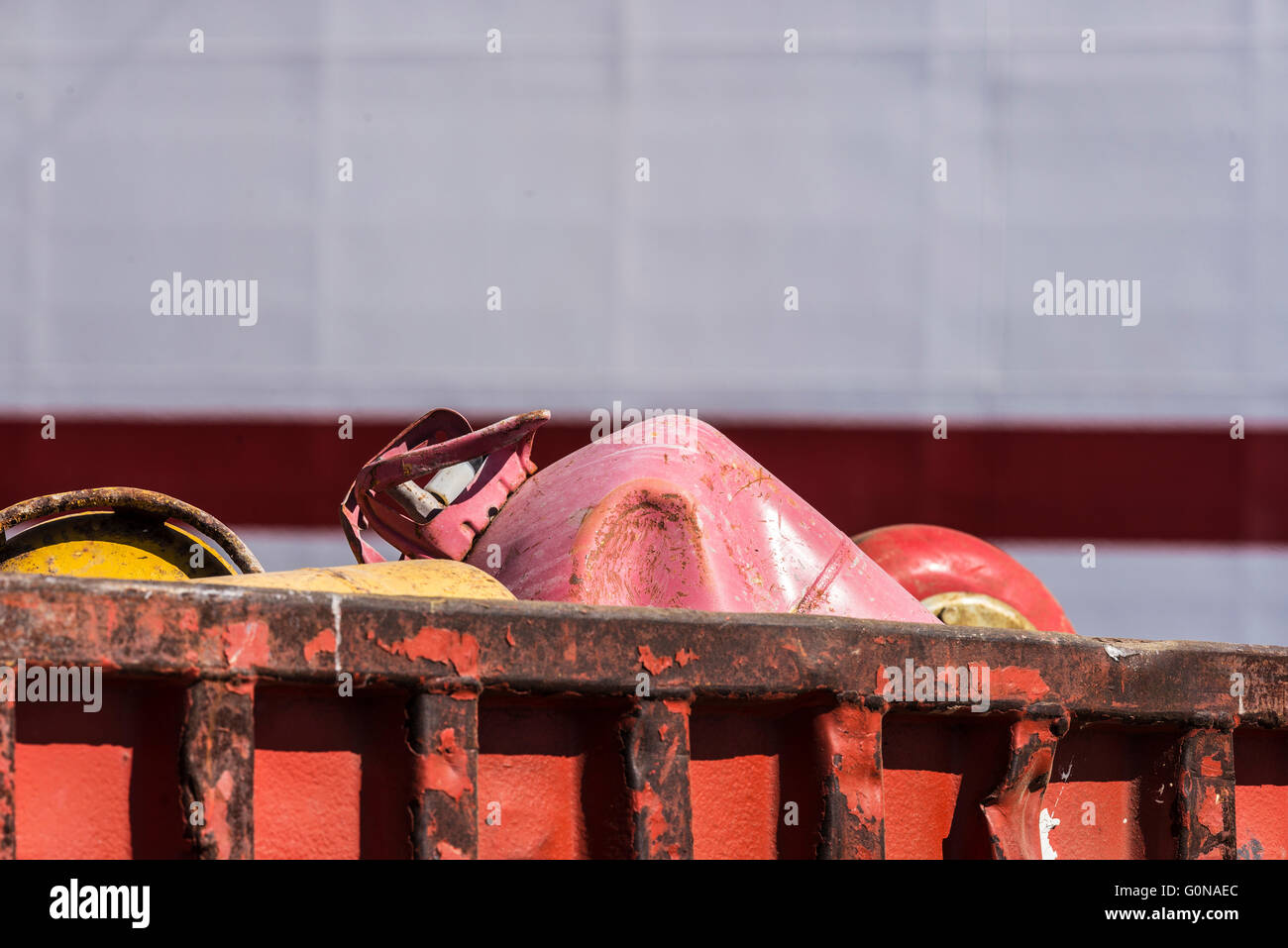 Contenitore di scarto con bombole di gas butano in attesa di imbarcarsi presso il porto Foto Stock