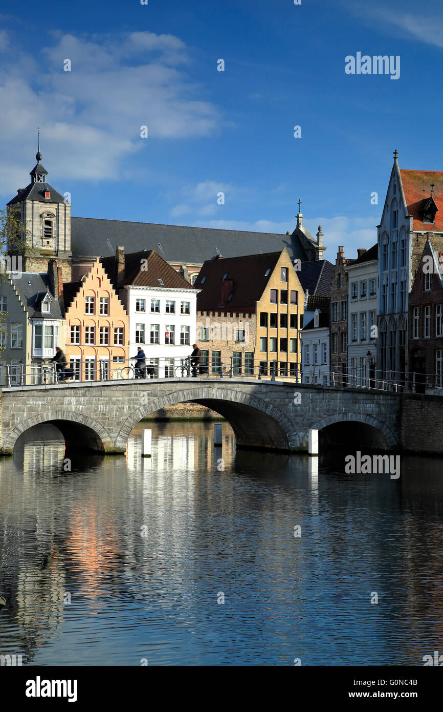 Case, canal, e ciclisti attraversando il ponte, Bruges, Belgio Foto Stock