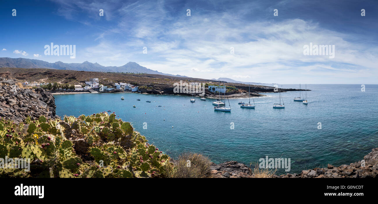 Imbarcazioni da diporto portando i turisti sulle escursioni ormeggiare nella baia fuori dalla porta isolata villaggio di El Puertito a Adeje, Tenerife, Foto Stock