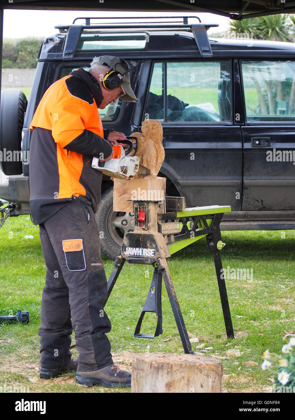 Un uomo intaglia sculture in legno utilizzando una motosega Foto Stock