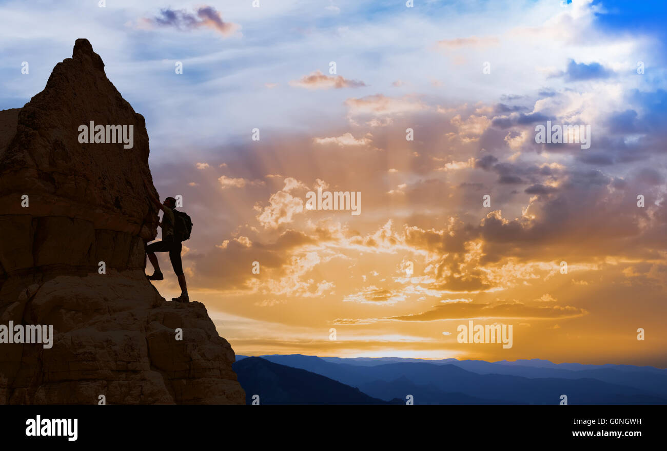 Silhouette di successo della donna di arrampicata in montagna nozione del concetto di motivazione del movimento di ispirazione al bel tramonto Foto Stock