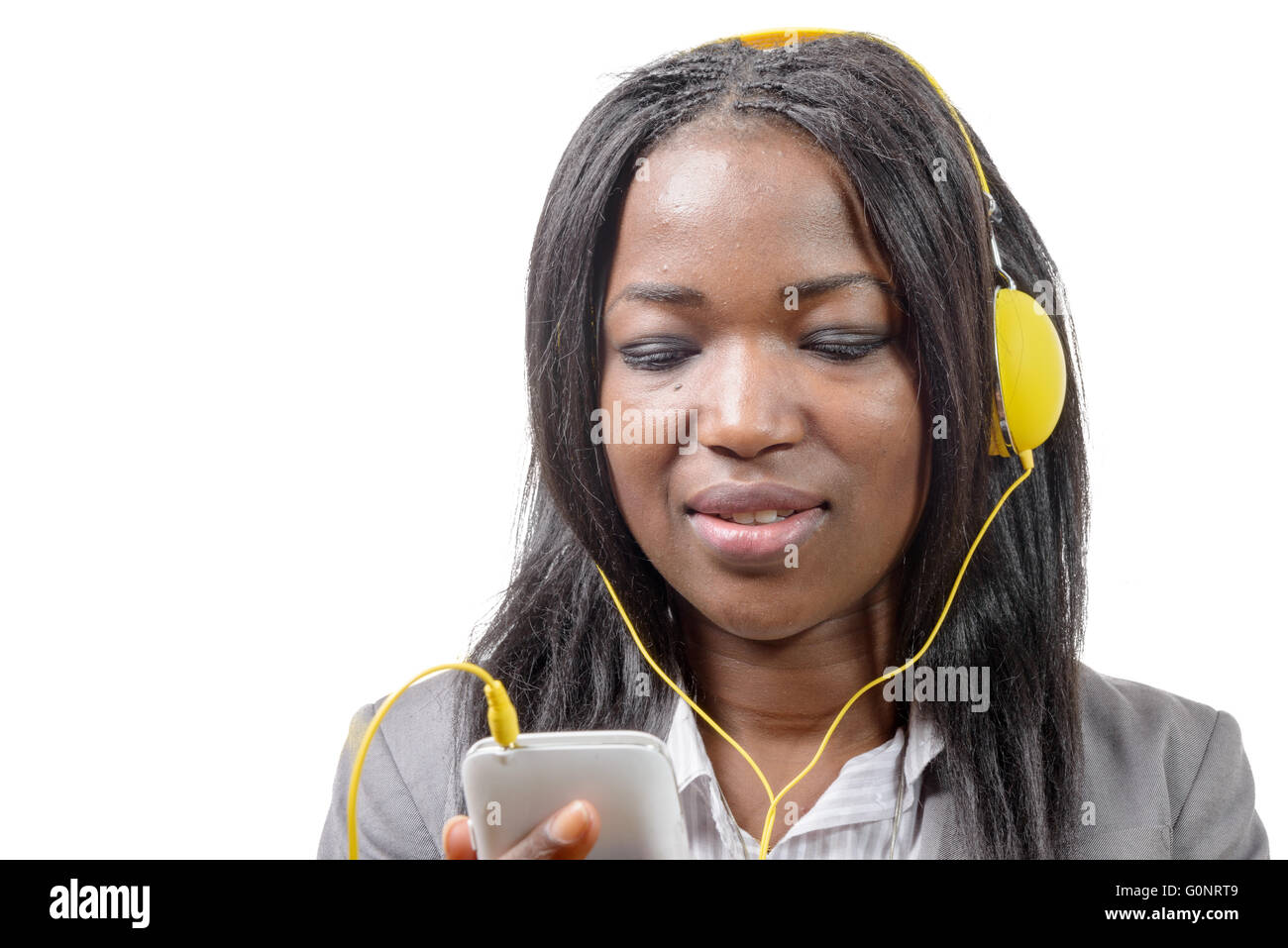 Allegro affascinante ragazza africana tenendo il telefono cellulare e ascolto di musica Foto Stock