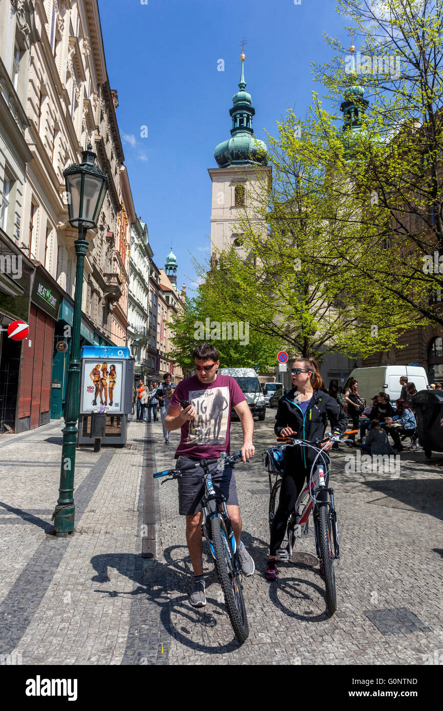 Turisti in bicicletta in Havelska Street sullo sfondo St Havel Chiesa, Praga Città Vecchia Repubblica Ceca Foto Stock